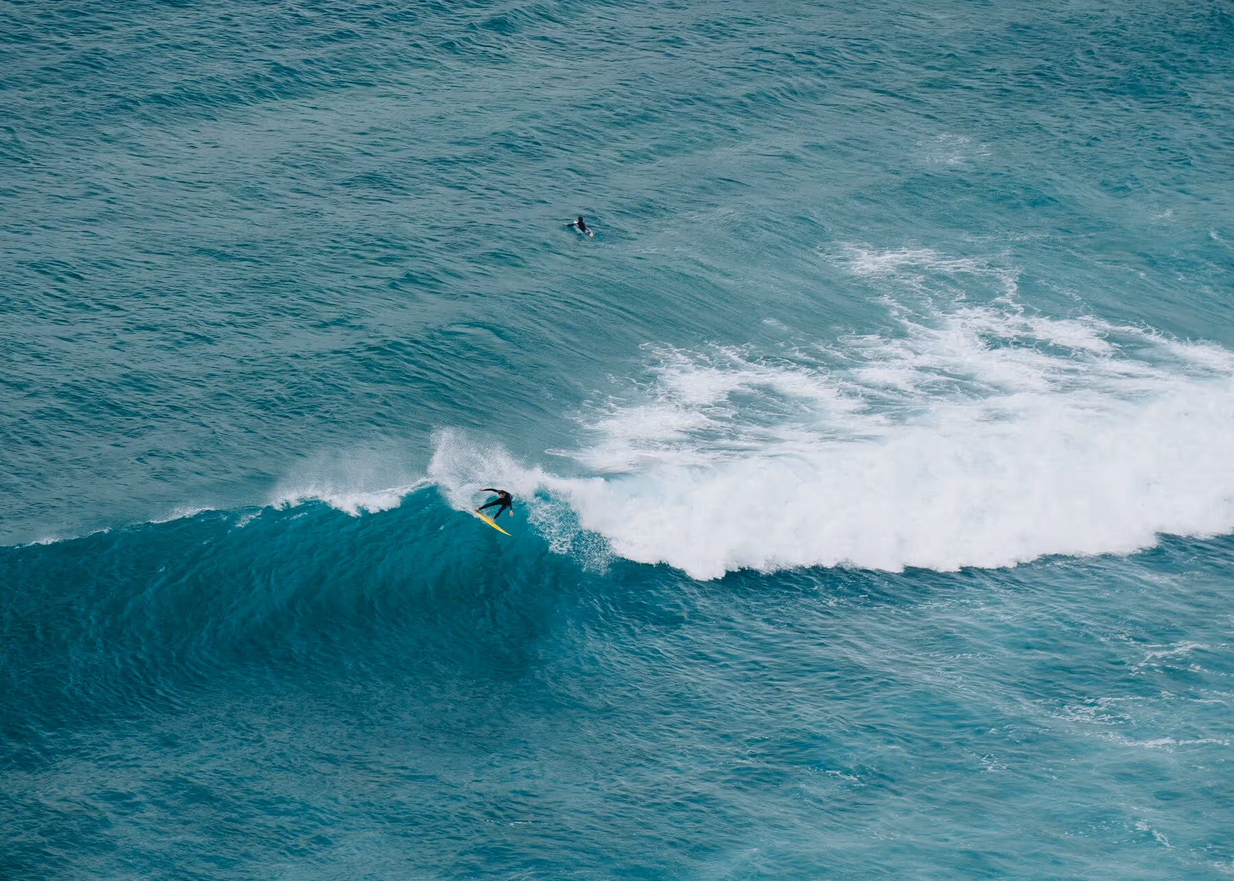 An aerial view of turquoise surf