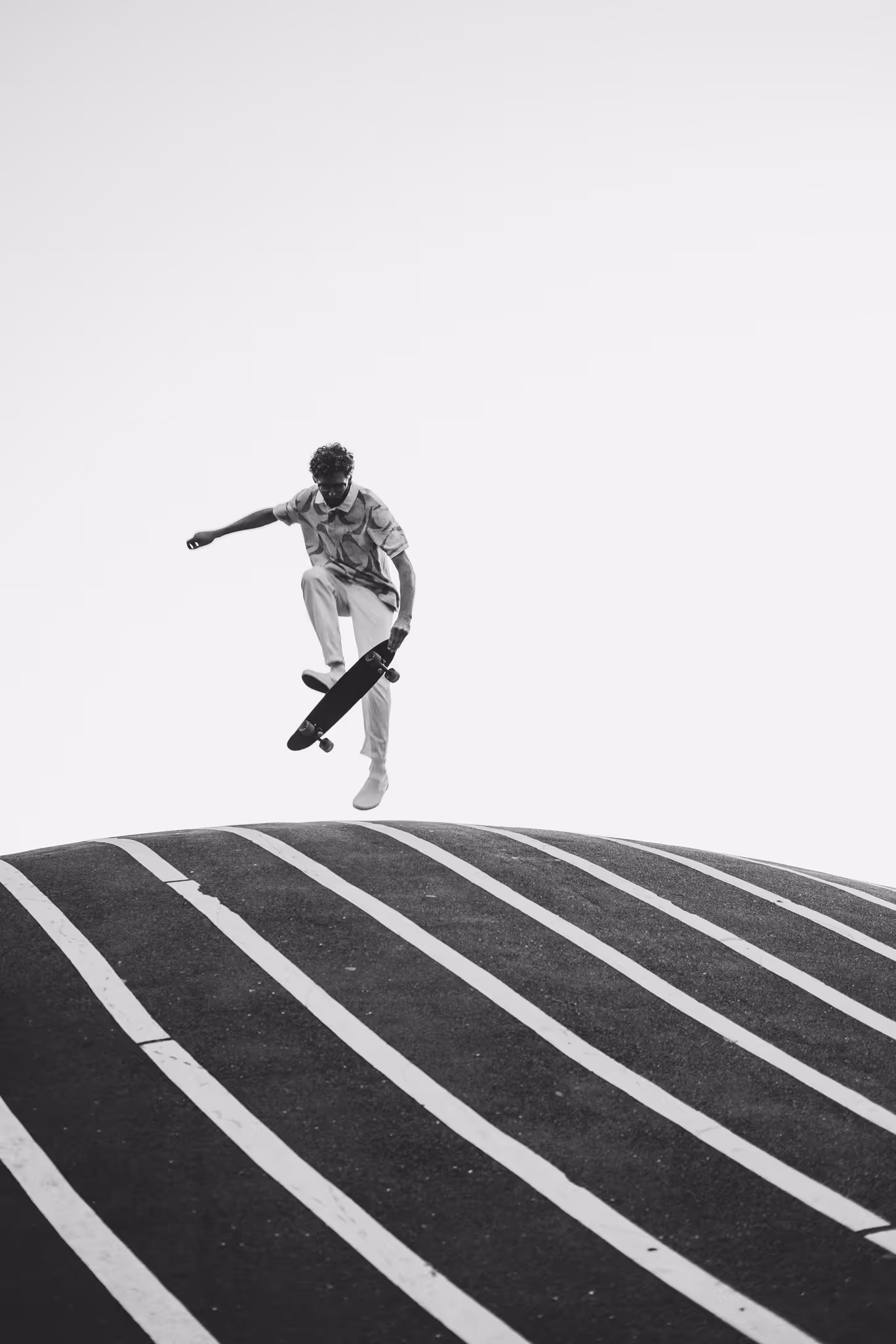 A skateboarder airborne above a striped bank in Copenhagen