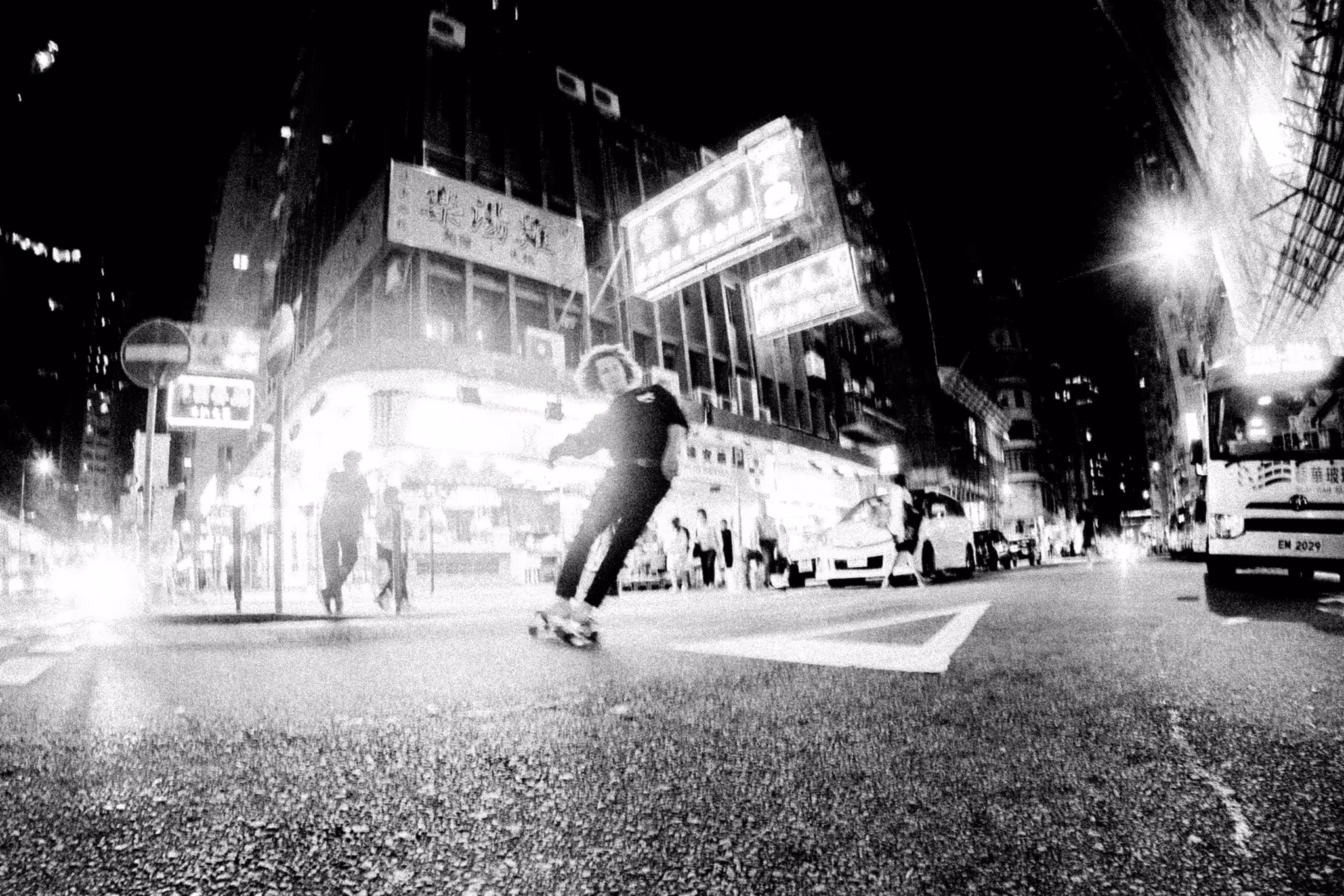 A skateboarder moving through a Hong Kong street at night